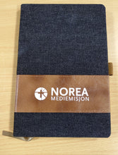 Notatbok med penn og Norea-logo