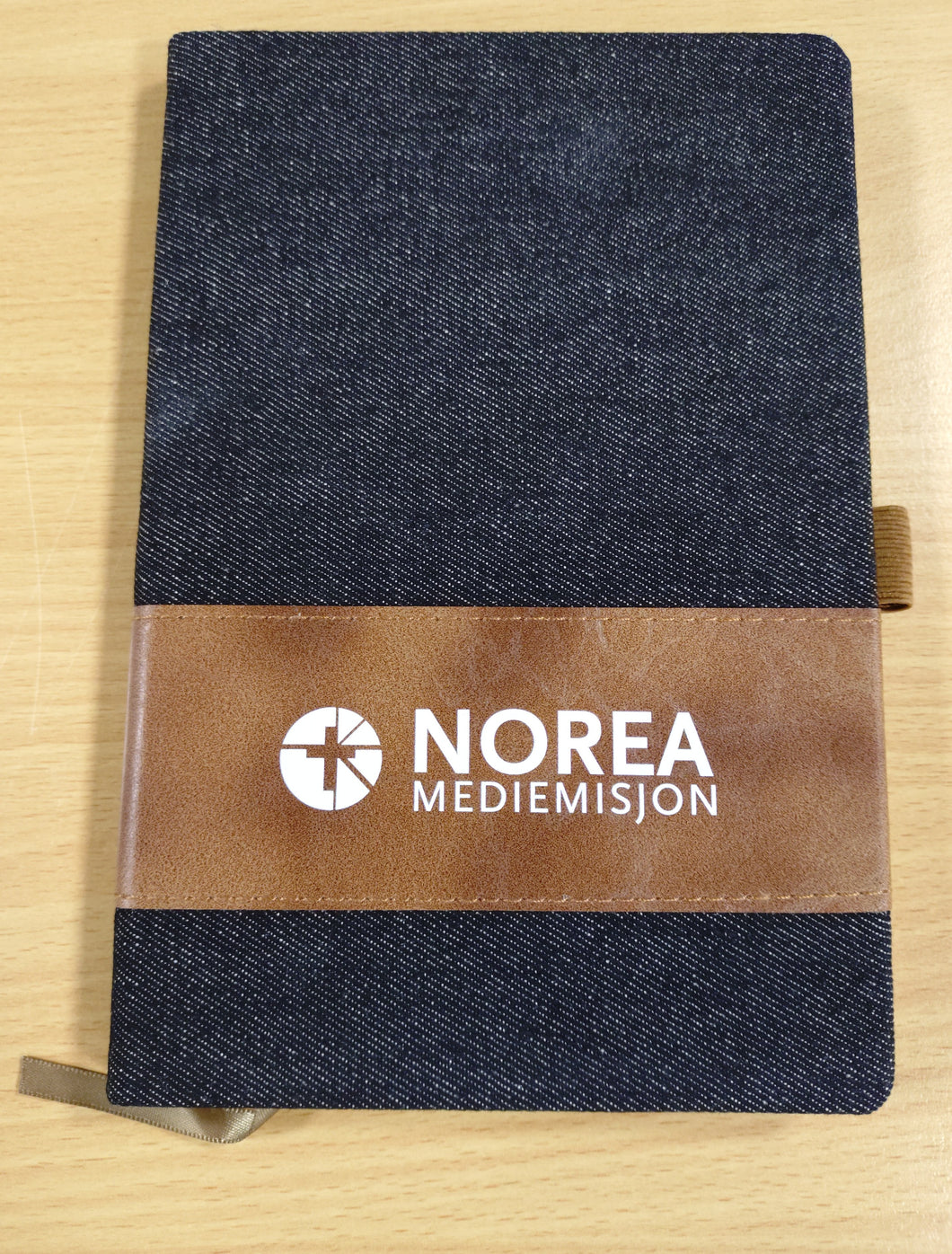 Notatbok med penn og Norea-logo